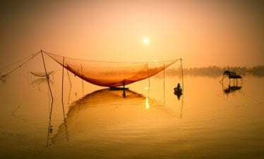 unidentified-fisherman-checks-his-nets-in-early-morning-on-river-in-hoian-vietnam-hoi an