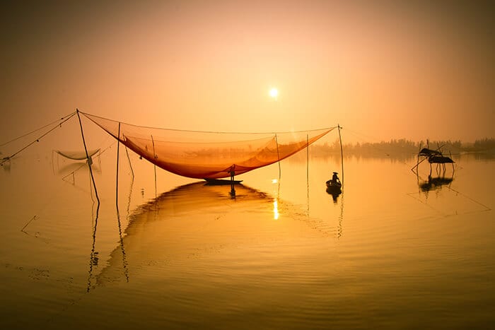 unidentified-fisherman-checks-his-nets-in-early-morning-on-river-in-hoian-vietnam-hoi an