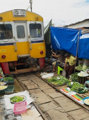 train-passes-by-the-mae-klong-railway-tracks-market-in-samut-songkram-thailand-100119117